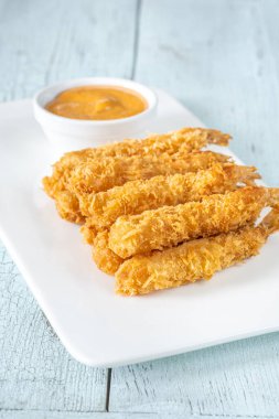 Beyaz tabakta soslu karides tempura.