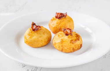 Bol yağda kızartılmış patatesli parmesan topları ve pastırma.