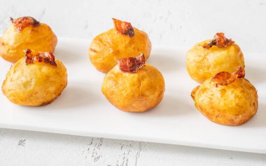 Bol yağda kızartılmış patatesli parmesan topları ve pastırma.