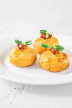 Bol yağda kızartılmış patatesli parmesan topları ve pastırma.