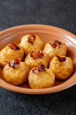 Bol yağda kızartılmış patatesli parmesan topları ve pastırma.