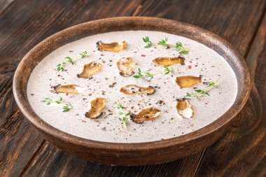 Erizengiyle süslenmiş bir kase mantar kremalı çorba. 