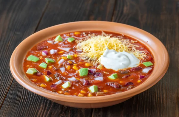 Bowl of taco soup garnished with cheese and sour cream