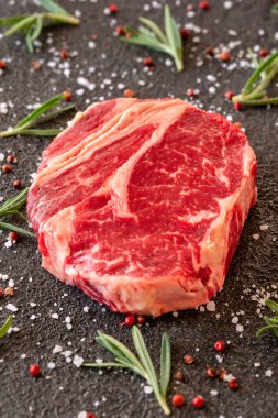 Siyah arka planda pişmemiş biftekli biftek.