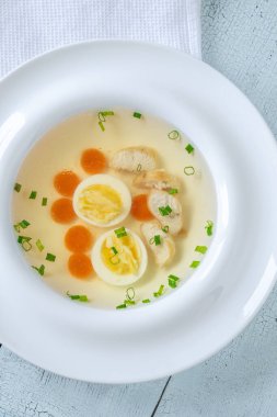 Beyaz tabakta temiz tavuk suyu çorbası.
