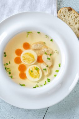 Beyaz tabakta temiz tavuk suyu çorbası.