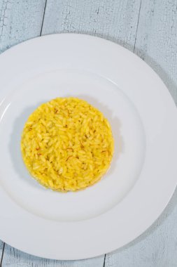 Beyaz tabakta safranlı risotto.