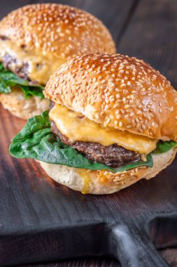 Ahşap arka planda iki ev yapımı cheeseburge
