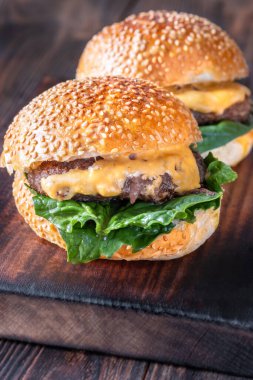Ahşap arka planda iki ev yapımı cheeseburge
