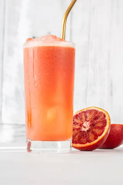 白い背景の血の赤いオレンジ ジュースのガラス ストック写真