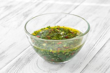 Masanın üzerinde bir kase Chimichurri sosu var.