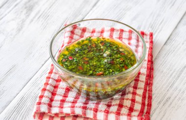 Masanın üzerinde bir kase Chimichurri sosu var.