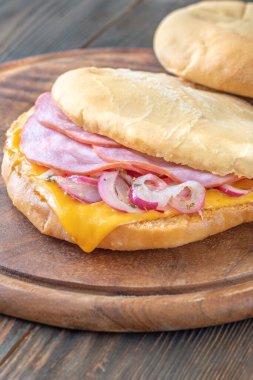 Jambonlu, peynirli ve marine edilmiş soğanlı Pita sandviçi.
