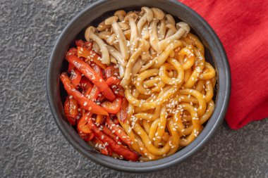 Bir kase biber ve mantarlı udon eriştesi.