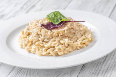Taze pazı yapraklarıyla kaplı kremalı risotto, canlı ve lezzetli.