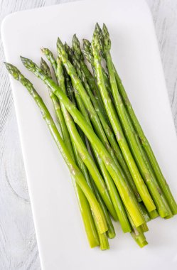 İnce sapları nemle parlıyor, her parlak yeşil mızrak mükemmel hassasiyetle pişiriliyor.