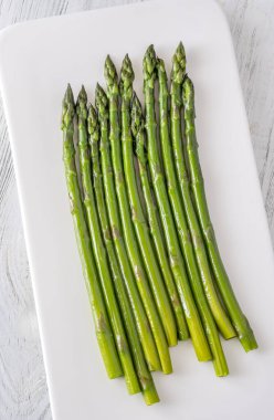 İnce sapları nemle parlıyor, her parlak yeşil mızrak mükemmel hassasiyetle pişiriliyor.