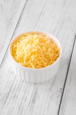 Beyaz kasede parlak rendelenmiş çedar peyniri, eritmek ya da tepelemek için mükemmel.