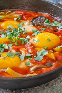 Baharatlı domates soslu yumurta, mantar, biber ve taze otlar.