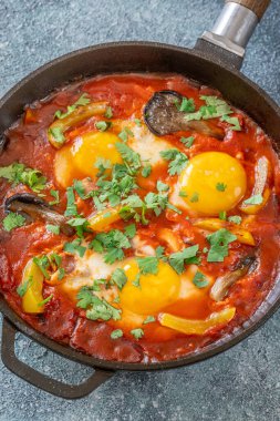 Baharatlı domates soslu yumurta, mantar, biber ve taze otlar.