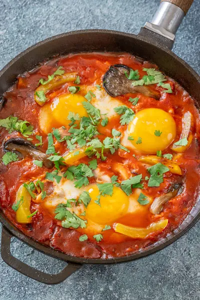 Baharatlı domates soslu yumurta, mantar, biber ve taze otlar.