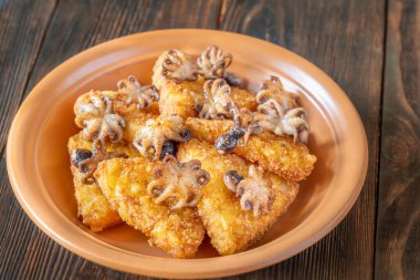 Kızarmış patates börekleri, güpegündüz aşınmış odunların üzerinde yumuşak ahtapotlarla eşleştirilir.