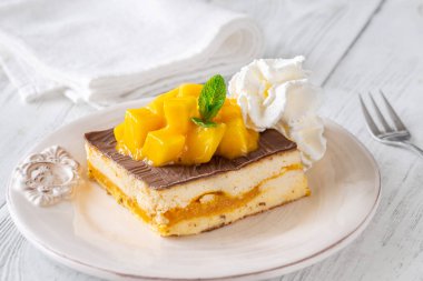 Krem şanti, çikolata sosu ve mango ile servis edilen tropik tatlı meydanı.