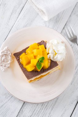 Krem şanti, çikolata sosu ve mango ile servis edilen tropik tatlı meydanı.