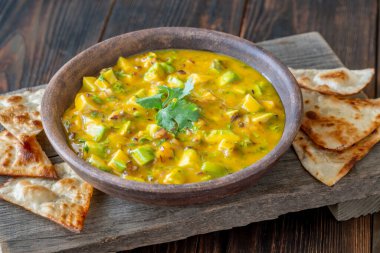 Üçgen tortilla cipsi. Mango, avokado, kişniş ve kırmızı soğanlı salsa sosu.