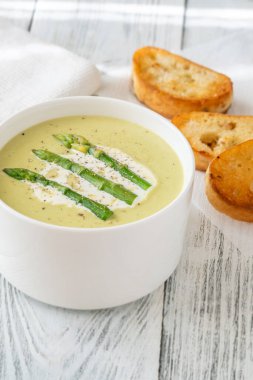 Mızraklı kadife yeşil çorba, krema ve kızarmış ekmek.