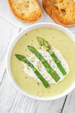 Mızraklı kadife yeşil çorba, krema ve kızarmış ekmek.