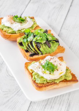 Avokado, yumurta, kurutulmuş domates ve balzamik soslu kızarmış ciabatta.