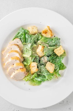 Kıtır marul ve kızarmış tavuk karışımı kremalı Sezar sosu sunumu