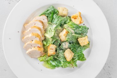 Kıtır marul ve kızarmış tavuk karışımı kremalı Sezar sosu sunumu