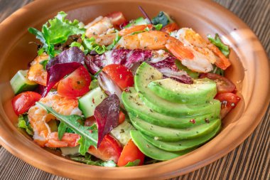 Canlı salata karidesleri avokado taze yeşiller narenciye soslu ahşap masa kırsalları.