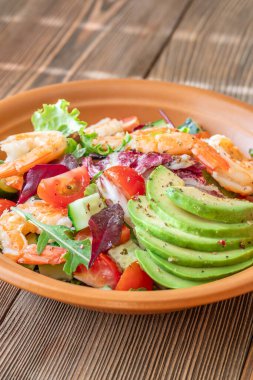 Canlı salata karidesleri avokado taze yeşiller narenciye soslu ahşap masa kırsalları.
