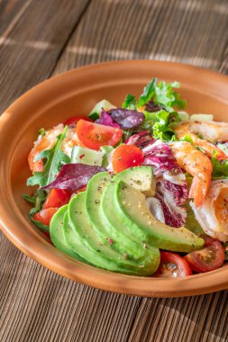 Canlı salata karidesleri avokado taze yeşiller narenciye soslu ahşap masa kırsalları.