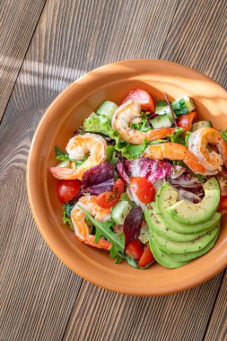 Canlı salata karidesleri avokado taze yeşiller narenciye soslu ahşap masa kırsalları.