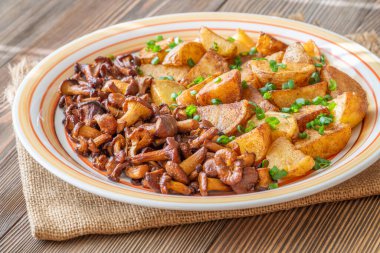 Altın patates chanterelle mantarları çıtır çıtır kırmızı paprika rustik servis.