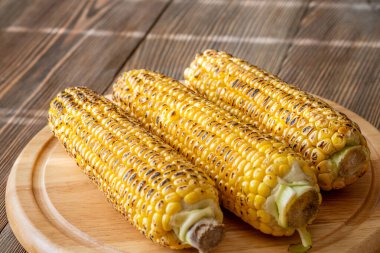 Kırsal kesim tahtasına hafifçe konana kadar kızartılmış canlı sarı mısır.