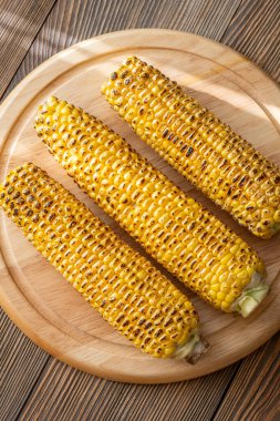 Kırsal kesim tahtasına hafifçe konana kadar kızartılmış canlı sarı mısır.