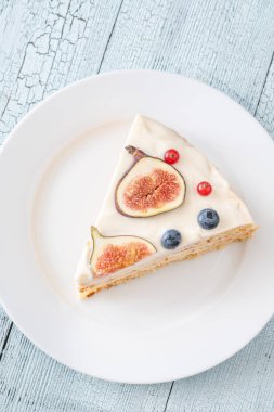 Krem peynirli pasta üzerine incir üzümlü üzümlü üzümlü beyaz tabak servis edildi.