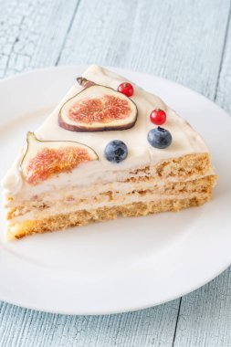 Krem peynirli pasta üzerine incir üzümlü üzümlü üzümlü beyaz tabak servis edildi.