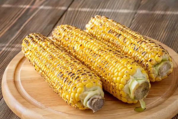 Kırsal kesim tahtasına hafifçe konana kadar kızartılmış canlı sarı mısır.