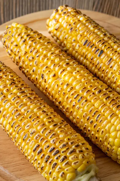 Kırsal kesim tahtasına hafifçe konana kadar kızartılmış canlı sarı mısır.
