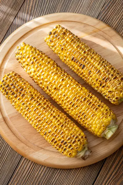Kırsal kesim tahtasına hafifçe konana kadar kızartılmış canlı sarı mısır.