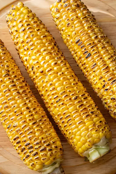 Kırsal kesim tahtasına hafifçe konana kadar kızartılmış canlı sarı mısır.