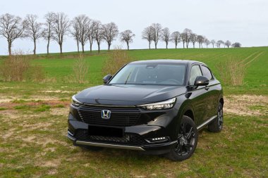 Puck, Polonya - 16 Nisan 2023: Kır yolundaki bir tarlada park edilmiş siyah Honda HR-V melezinin yeni modeli