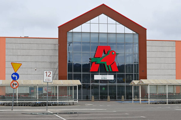 Рубеж, Польша - 16 апреля 2023 года: логотип Auchan на фасаде магазина. Auchan - французская сеть гипермаркетов