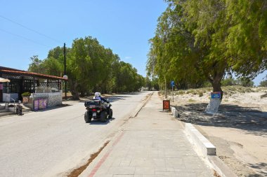 Kos, Yunanistan - 7 Mayıs 2023: Marmari, Kos Adası 'nda sahil yolu boyunca bisiklet süren turistler. Yunanistan